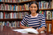 © peopleimages.com - College, portrait and woman student in library with notebook for education, learning or studying for exam. Scholar, smile and Indian person writing for revision, knowledge or test on biology course