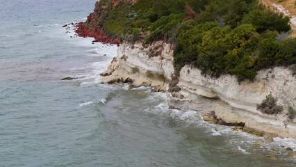 Wall Mural - Aerial 4k video of waves hitting the rocks on the beach