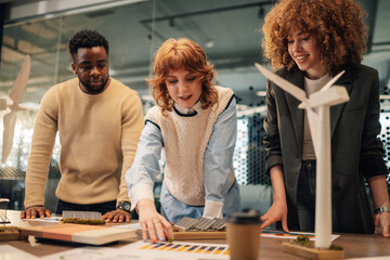 Diverse businesspeople analyzing charts for renewable energy solution.