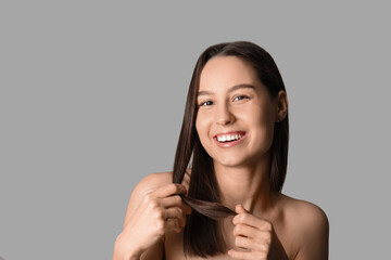 Poster - Young dark-haired woman on grey background