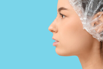 Poster - Young woman in medical hat with marks on her nose before plastic surgery against blue background, closeup