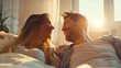 © Elena - A young pretty couple, a guy and a girl, look at each other lovingly, sitting on the couch, in the rays of the bright sun, people relationship