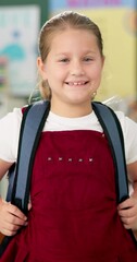 Poster - Student, girl and face with backpack in classroom for education, back to school and ready for knowledge. Scholar, portrait and excited at preschool with confidence for learning, studying and lesson