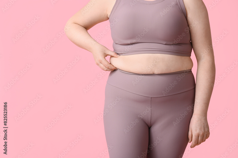 Overweight woman on pink background. Diet concept