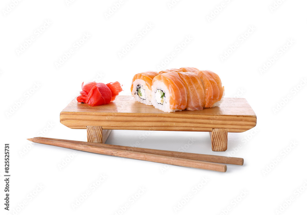 Board with tasty sushi rolls, marinated ginger and chopsticks on white background