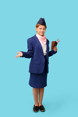 Canvas Print - Portrait of teenage stewardess with passport and tickets on blue background