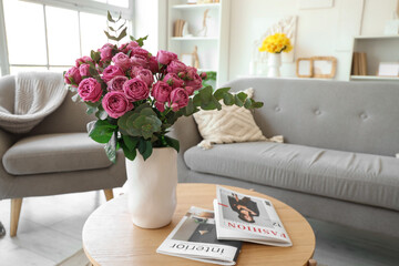 Wall Mural - Vase with pink roses and magazines on table in living room, closeup