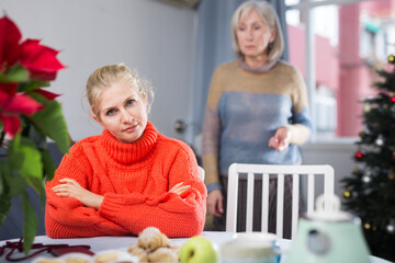 Wall Mural - Mature woman quarrels with her adult daughter, who came to visit her before Christmas, scolding her