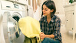 © Zhanna - Young girl puts clothes in the washing machine.