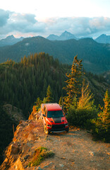 Wall Mural - Aerial shot of shot of a pickup truck standing on the cliff with a backdrop of North Cascades Mountains in Snoqualmie Pass, Washington State. 