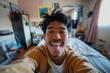© Nadia Do - Realistic phone selfie made by a young asian guy showing tongue, at home without filters