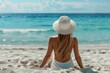 © YURIMA - A woman in a white hat is peacefully enjoying a moment on a sunny beach, looking out at the ocean. It exudes tranquility and offers an escape to a tropical paradise, a serene retreat
