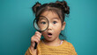 © The Stock Photo Girl - Portrait of surprised cute little asian girl looking through a magnifying glass. Education concept