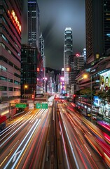 Wall Mural - A bustling city at night with heavy traffic, showcasing the vibrant lights and towering skyscrapers of downtown Hong Kong The streets are filled with moving cars, creating streaks of light in