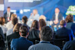 © Anton Gvozdikov - Attendees watch and listen to a panel of speakers discussing topics at a professional business conference. The focus is on the engaged audience.