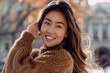 © BetterPhoto - A woman with long brown hair is wearing a brown sweater and smiling