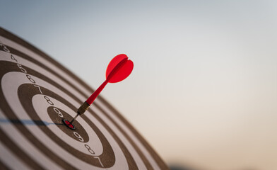 Canvas Print - Close up shot red darts arrows in the target center on dark blue sky background. Business target or goal success and winner concept.