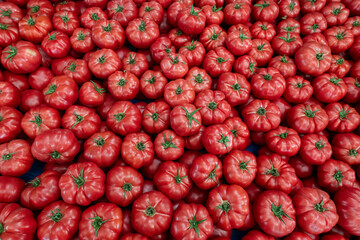 Wall Mural - Clean eating concept. Bunch of ripe juicy freshly picked organic tomatoes in pile at local produce farmers market. Healthy diet for spring summer detox. Vegan raw food. Close up, background.