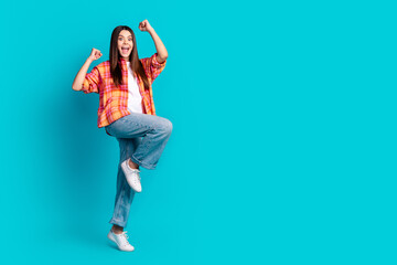 Sticker - Full size photo of nice young girl raise fists empty space ad wear plaid shirt isolated on teal color background