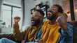© john - Excited african american father and adult son watching sport on tv and celebrating victory