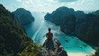 © SONGPOL - A lone traveler enjoys a panoramic view of may beach, Krabi, Thailand and turquoise waters from a scenic overlook. The movie lights.