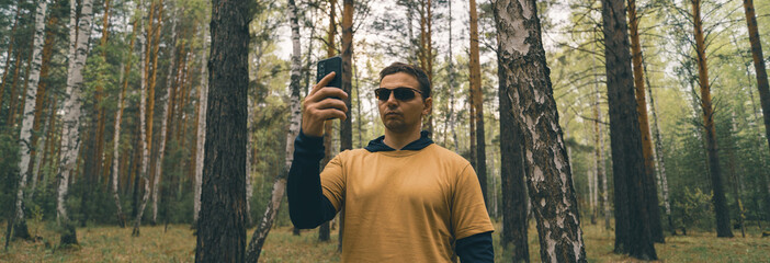 Poster - person with smart phone in the woods