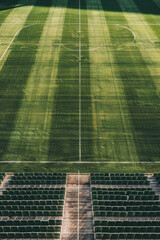 Wall Mural - Aerial view of an empty sports stadium, capturing the symmetrical arrangement of seats and the clean lines of the field. Highlight the minimalist beauty of the structured space 