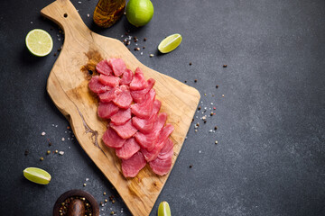 Wall Mural - Sliced tuna steak on a wooden cutting board at domestic kitchen