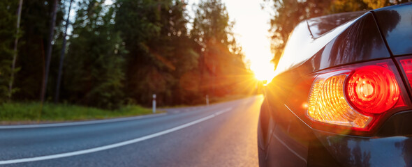 Wall Mural - Panoramic view of the car on the asphalt highway on sunset.