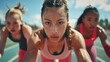 © LukaszDesign - The stadium track race starting line has three female participants. Sporty young women ready to race. Diversity at the sprint line or starting blocks