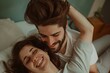 © LukaszDesign - Happy couple in bed in their bedroom with a smile. Young male and female romance, dating, and intimacy in a house