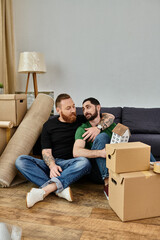 Wall Mural - A gay couple relaxes on top of a couch in their new home filled with moving boxes, beginning a new chapter in their lives.