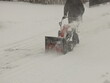 © Xato Lux - Robotnik clears snow from the sidewalk with a manual snowplow driven by a gasoline engine. Fighting the after-effects of a snowstorm. The power of the winter element