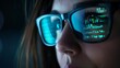 © Nene - Closeup of a Female IT Professional's Face with Glasses Reflecting Computer Code in a Dark Room for a High-Tech and Intense Atmosphere