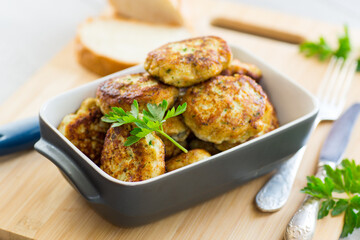 Wall Mural - fried meat cutlets in a ceramic form on a wooden table