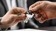 © Shahriyar - A realtor handing over house keys to a new homeowner as they shake hands in front of a newly purchased home.