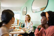 © Marko Geber - Diverse female employees eating lunch together in office