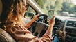 © Shahriyar - woman driving car holding phone with map app open, real photo