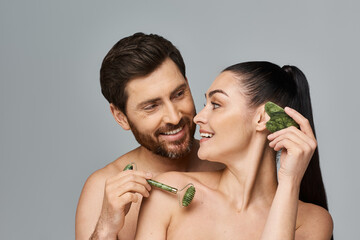 Wall Mural - A portrait of an attractive couple applying skincare.