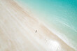 © AmazingAerialAgency - Aerial view of turquoise waters and sandy shore with person at Gantheaume Beach, Cable Beach, Western Australia, Australia.