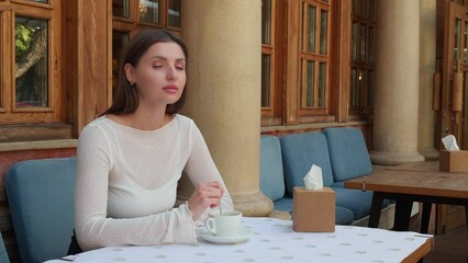 Poster - Beautiful woman drinking coffee in outdoor cafe