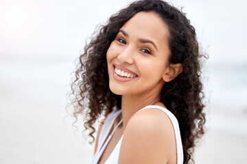 Poster - Portrait, smile and travel with woman on beach for holiday or vacation as island or paradise tourist. Morning, nature and summer with happy person on tropical coast to relax by ocean or sea for peace