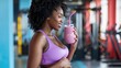 © cvetikmart - Fit pregnant black woman enjoying a smoothie after a prenatal workout in a gym setting. Pregnant black woman
