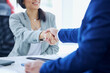 © peopleimages.com - Car dealership, documents and people with handshake in showroom and contract, consulting and meeting. Man, woman and smile with legal agreement in sale for automobile, application and success in deal