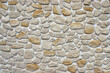 © kargona - Decorative stone wall made of natural rocks of different colors and shapes plastered with white mortar as a background