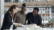 © john - Diverse business people looking at architectural model and discussing work at office