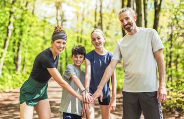 Wall Mural - A Family exercising and jogging together at an outdoor park hand on hand