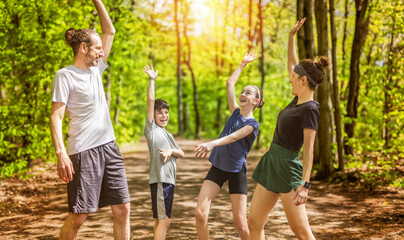 Wall Mural - A Family exercising and jogging together at an outdoor park hand on hand