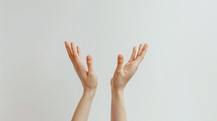 Canvas Print - Pair of hands raised with palms facing upwards, fingers slightly spread, against a plain, light-colored background