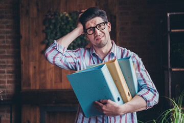 Poster - Portrait of young man office worker hold document folders wear shirt loft interior business center indoors